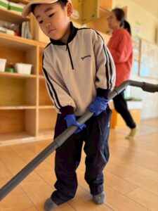 ベージュのジャージ姿で掃除機を使いこなす4歳男児がかっこいい