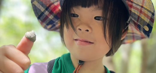 どんぐりの帽子を親指にはめた女の子
