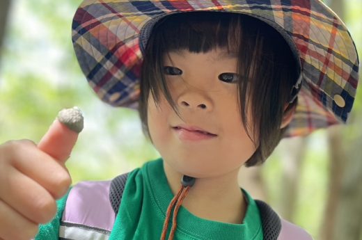 どんぐりの帽子を親指にはめた女の子